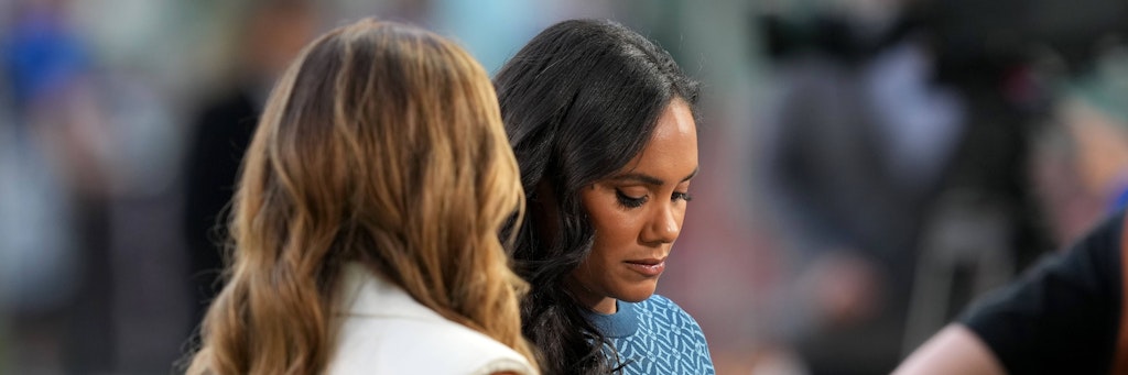 BBC-Moderatorin Alex Scott schaut auf die „One Love“-Kapitänsbinde in ihren Händen beim Spiel der Engländer gegen den Iran und trägt sie wenig später am linken Oberarm.