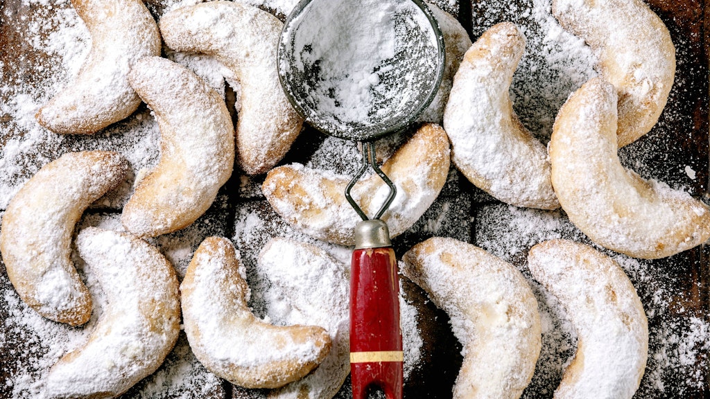 Für den perfekten Zuckermantel die Kipferl zunächst noch heiß mit Puderzucker-Vanillezucker-Mix bestreuen. Und ein zweites Mal, wenn die Plätzchen erkaltet sind.