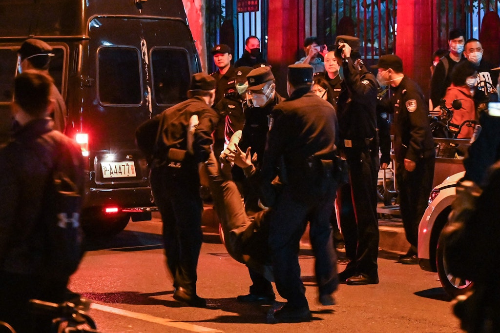 Ein Demonstrant wird in Shanghai von der Polizei weggetragen.