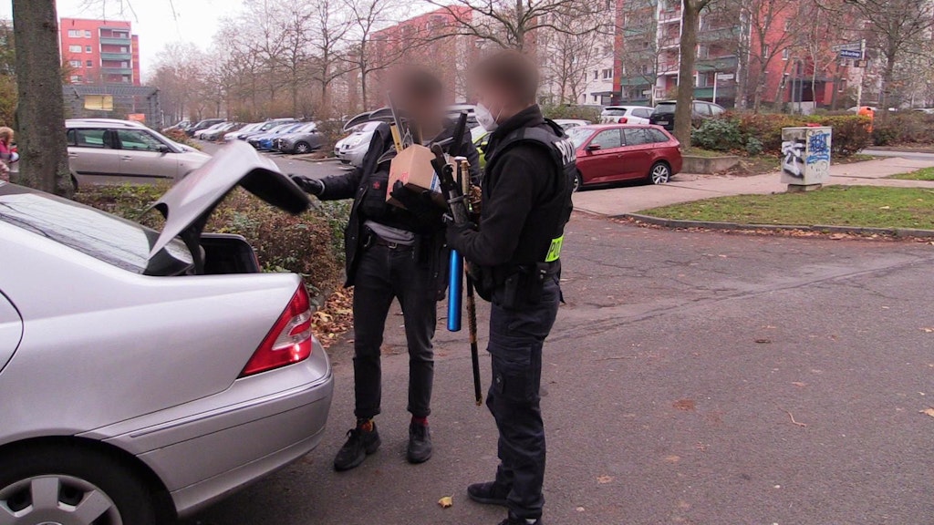 Polizeibeamte laden bei der Anti-Hass-Razzia beschlagnahmte Säbel, Macheten und Baseballschläger in ihr Zivilfahrzeug. Die Waffen stammen aus einer Wohnung an der Hellersdorfer Lily-Braun-Straße.