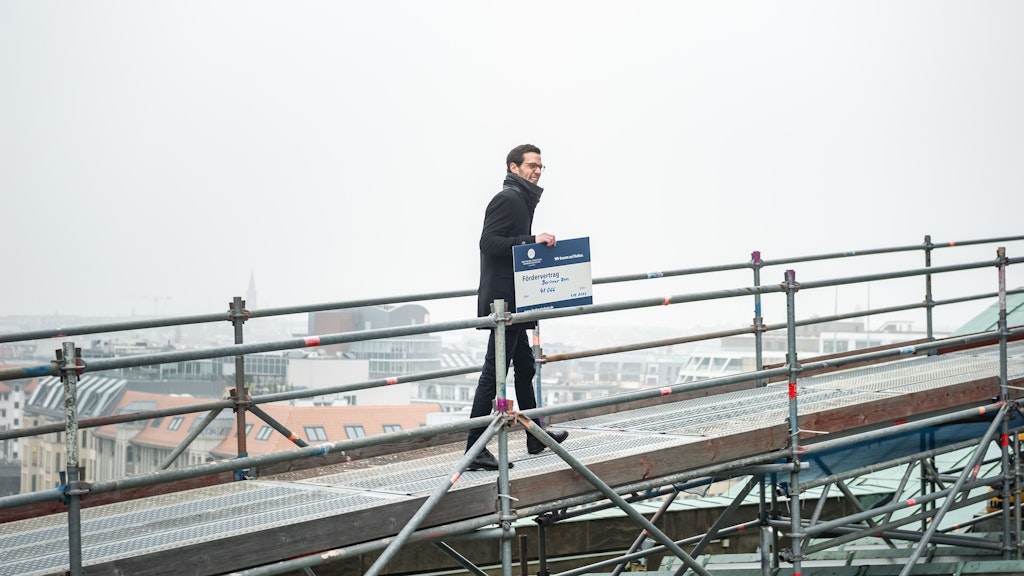 Dom-Geschäftsführer Jan Kingreen mit dem symbolischen Spenden-Scheck auf dem Dom-Dach.