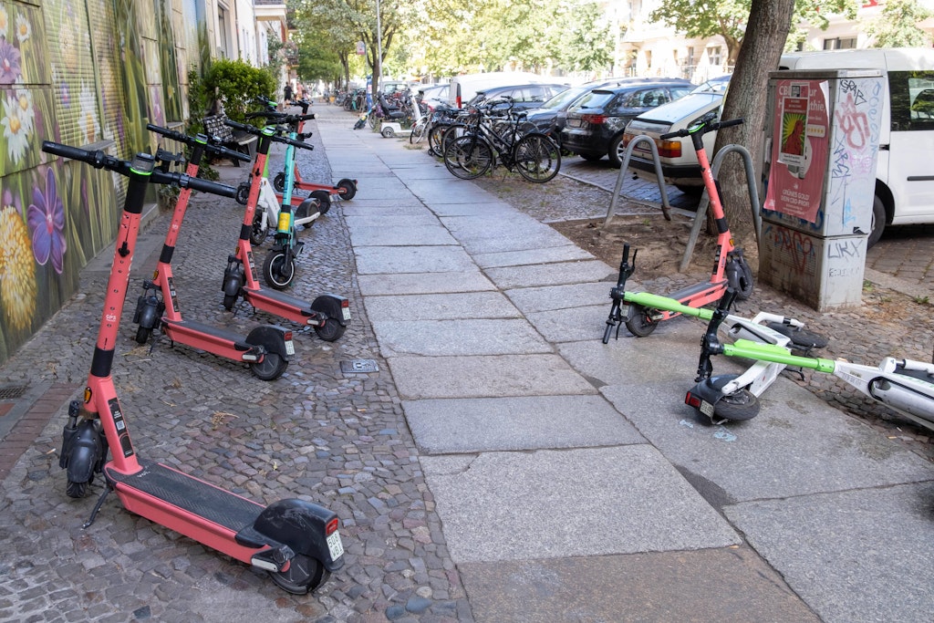 Auf einem Berliner Gehweg wahllos abgestellt E-Scooter. 