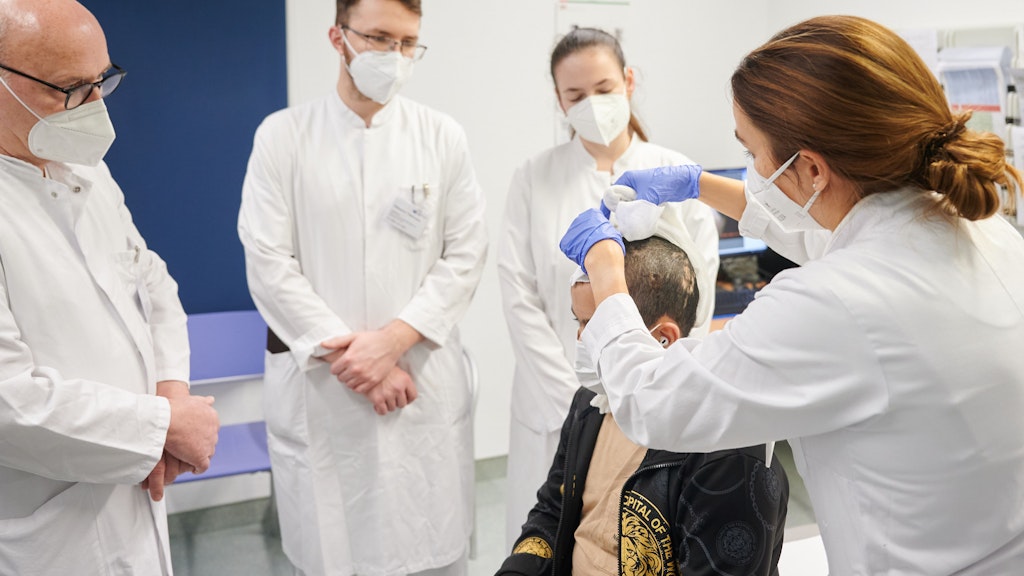  Bernd Hartmann (l-r), Chefarzt im Zentrum für Schwerbrandverletzte mit plastischer Chirurgie, Olexander Jazkowyna, ukrainischer Chirurg, Julia Huk, ukrainische Rehabilitationärztin und Jenny Dornberger, Oberärztin im Zentrum für Schwerbrandverletzte mit Plastischer Chirurgie versorgen den zehnjährigen Patienten Ebrahim. Ebrahim wurde im Syrienkrieg als Kleinkind aus einem brennenden Haus gerettet. 