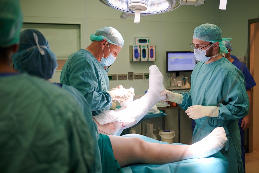 Olexander Jazkowyna, ukrainischer Chirurg (r), hilft Frank Sander, stellvertretender Chefarzt im Brandverletzungszentrum bei einer Operation im Unfallkrankenhaus Berlin