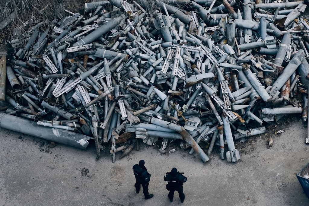 Symbol des Rüstungswahnsinns: Ukrainische Polizisten betrachten die Reste russischer Raketen, die in Charkiw eingesammelt wurden.