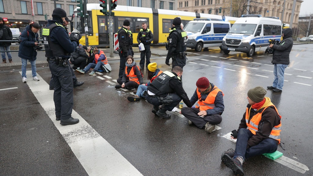 Klimaaktivisten blockieren am Montag die Invalidenstraße, haben sich auf der Fahrbahn festgeklebt.
