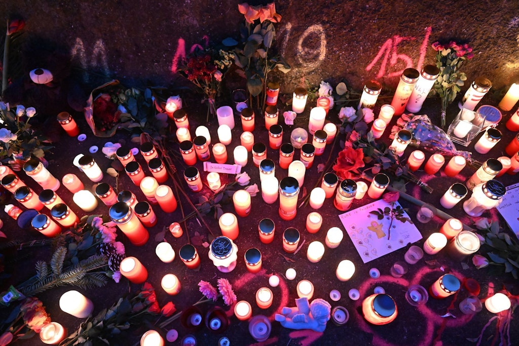 Kerzen und Blumen stehen an einem Tatort in Illerkirchberg, an dem am Tag zuvor zwei Mädchen von einem Mann mit einem Messer angegriffen wurden.