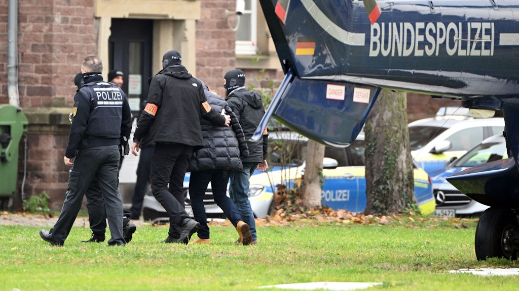 Ein Festgenommener (helle Schuhe) wird zum Haftrichter beim Bundesgerichtshof gebracht. Er wurde mit dem Hubschrauber nach Karlsruhe geflogen.