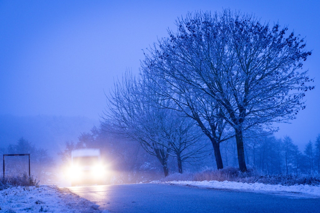 Ein Auto fährt über eine vereiste Straße. Das Wetter wird in den kommenden Wochen richtig eisig.