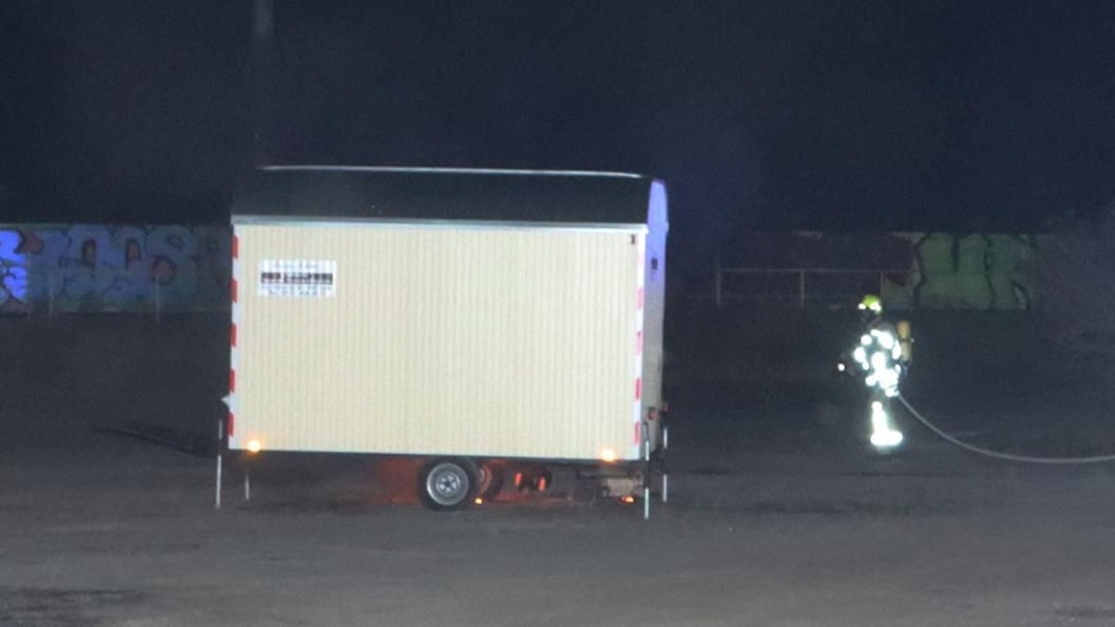 Ein Feuerwehrmann nähert sich dem Bauwagen, unter dem Feuerschein zu erkenne ist. Keiner ahnte in diesem Moment, dass ein Mann in dem Wagen war.