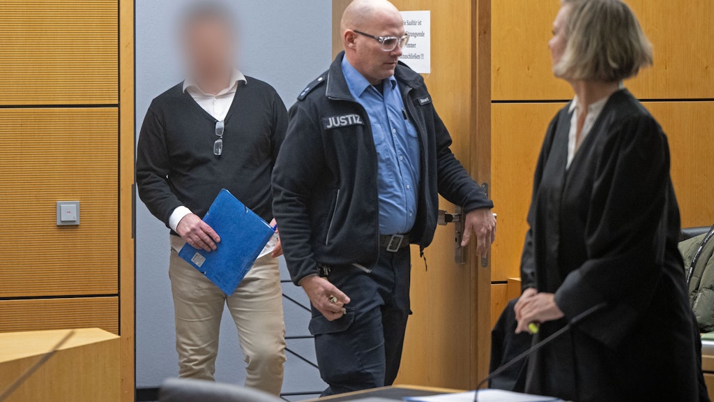 Der angeklagte frühere Geschäftsführer des mittlerweile insolventen Goldhändlers PIM (l.) kommt zu einer Verhandlung im Prozess um den insolventen Goldhändler am Landgericht Darmstadt in den Saal.