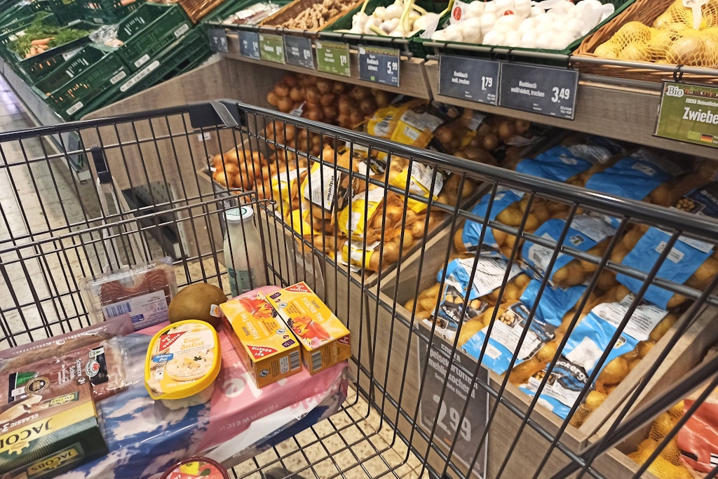 Ein Einkaufswagen steht in einem Discounter.