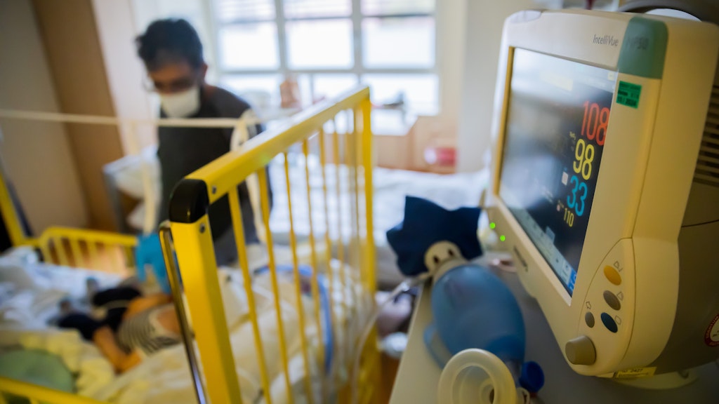 Die Apparate überwachen die Vitalfunktionen des kleinen Patienten, der Vater passt immer auf.