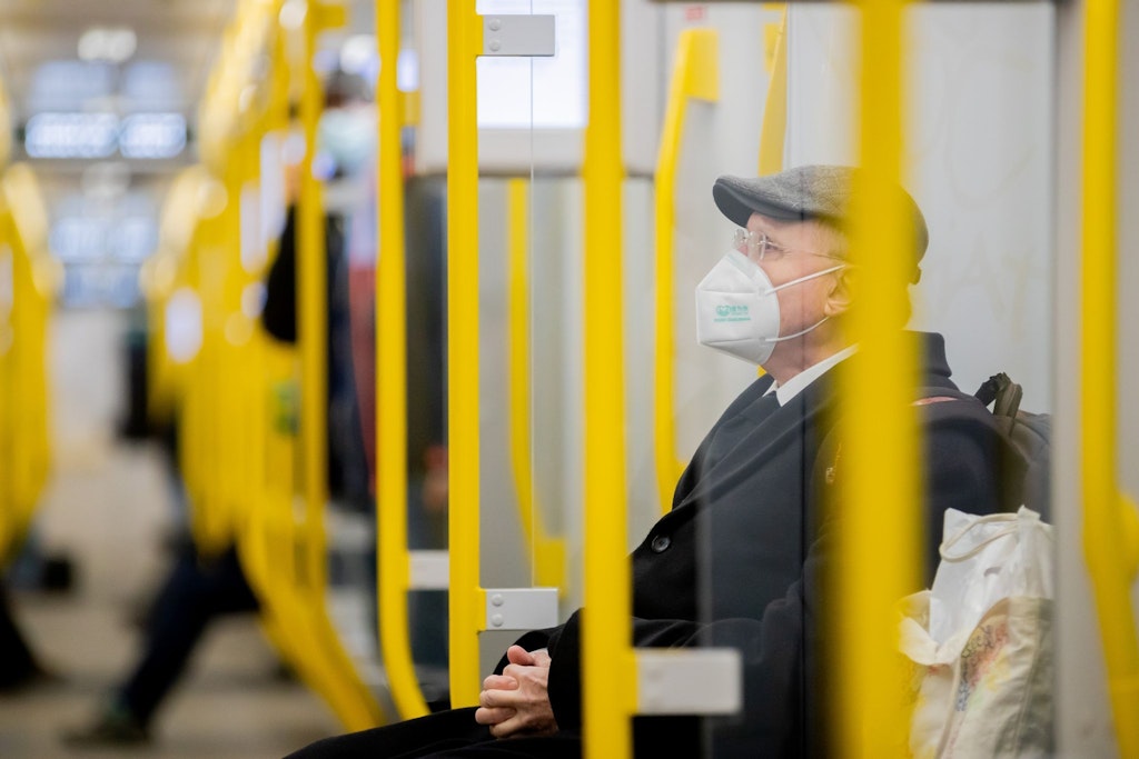 Mann sitzt mit FFP2-Maske in der U-Bahn.