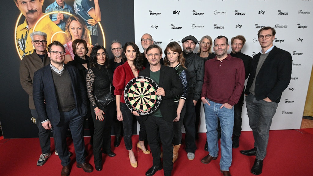 Florian Lukas mit Dartscheibe und Crew bei der Premiere von „Die Wespe“ in Berlin