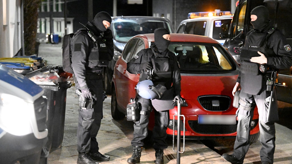 Solingen: Polizisten stehen im Rahmen einer groß angelegten Razzia mit einer Ramme zum Öffnen verschlossener Türen vor einem Haus. 