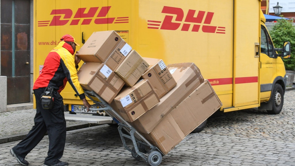 Ein Zusteller bringt Pakete. Doch nicht alle DHL-Sendungen werden bis zur Tür geliefert.
