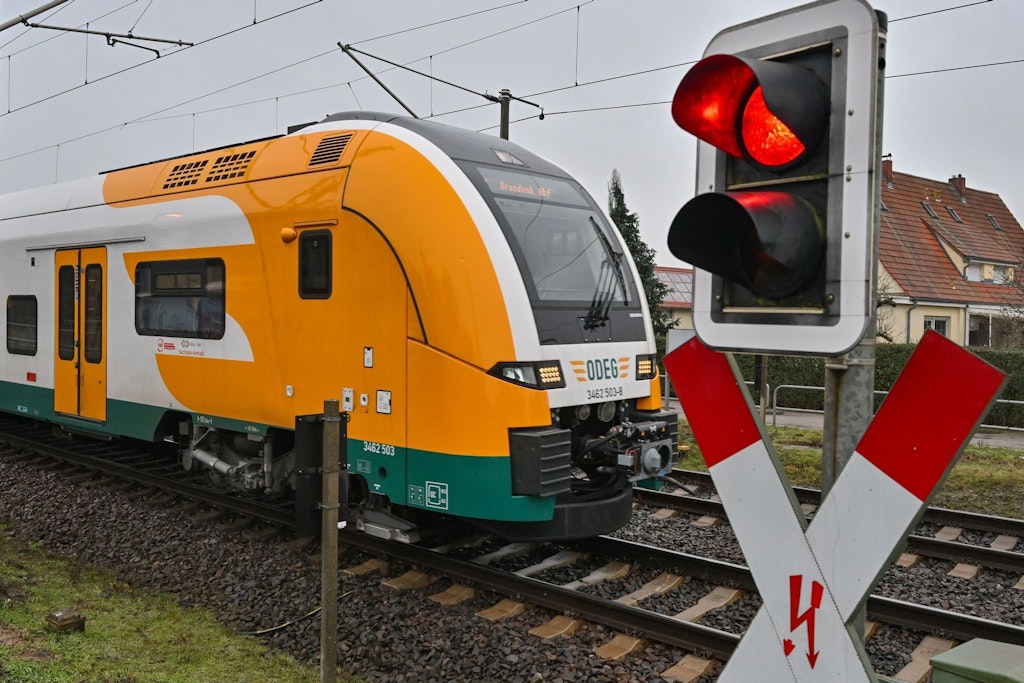 Der RE1 der Ostdeutschen Eisenbahngesellschaft (Odeg) fährt an einer Schranke vorbei.