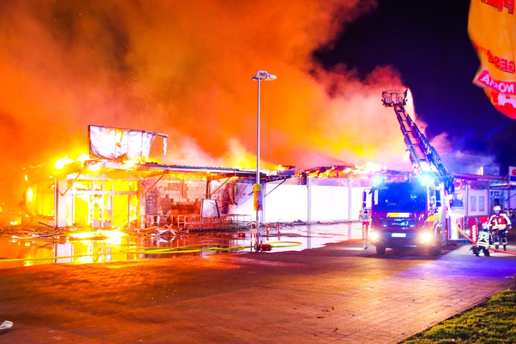 Die Feuerwehr löscht den brennenden Supermarkt.