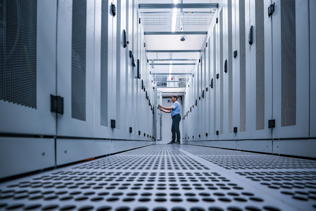 Ein IT-Mitarbeiter überprüft Serverschränke in einem Rechenzentrum.