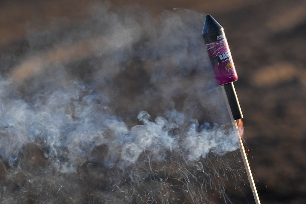 Eine angezündete Silvester-Rakete steckt im Boden - und nicht in einer Flasche (Archivbild). 