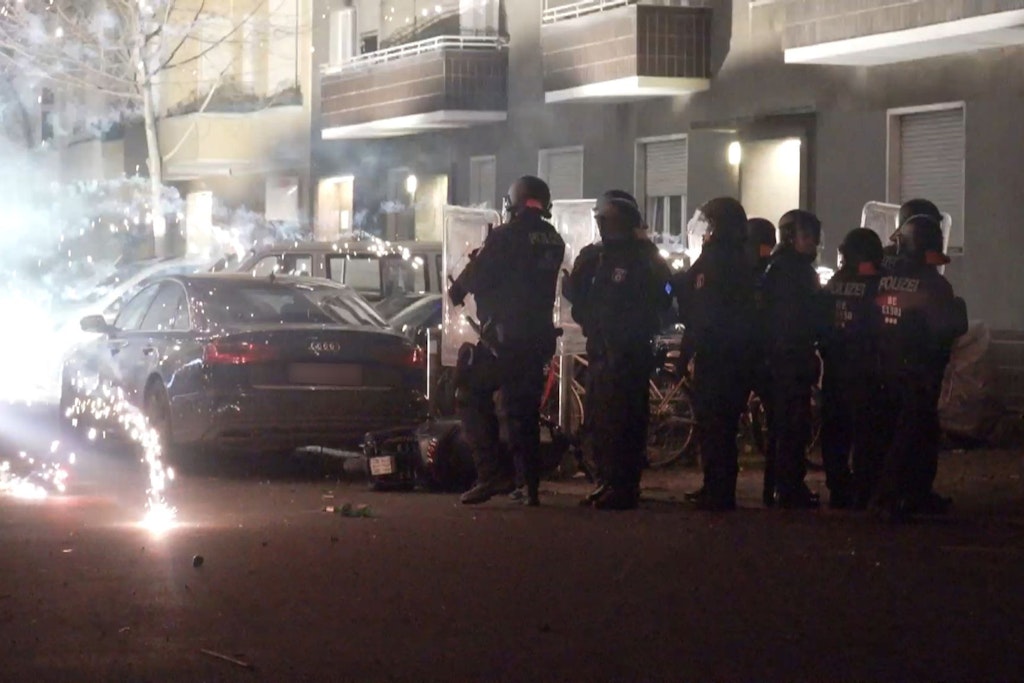 Polizeibeamte stehen hinter explodierendem Feuerwerk.