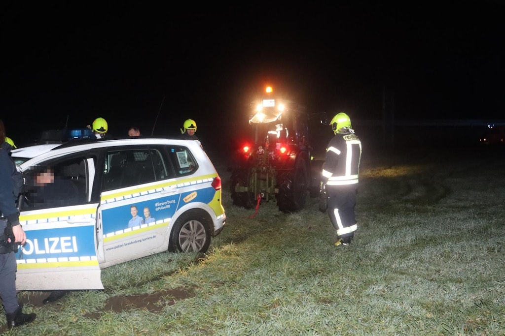 Vorschriftsmäßig mit gelbem Rundumlicht ausgestattet, zieht der Trecker den festgefahrenen Funkwagen in stockfinsterer Nacht aus dem Modder.