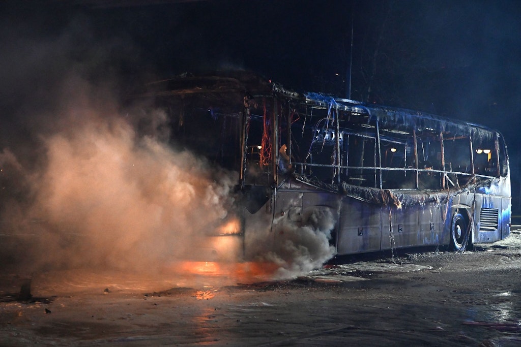 Brenzliger Silvester-Einsatz: Feuerwehrmänner löschen an der Sonnenallee einen Reisebus, der von Böller-Chaoten angezündet worden war.