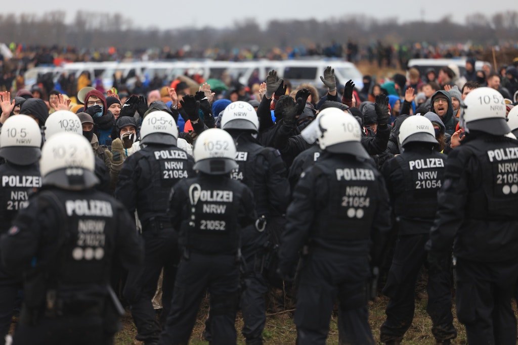 Polizisten und Demonstranten während der Demonstration von Klimaaktivisten am Rande des Braunkohletagebaus bei Lützerath.