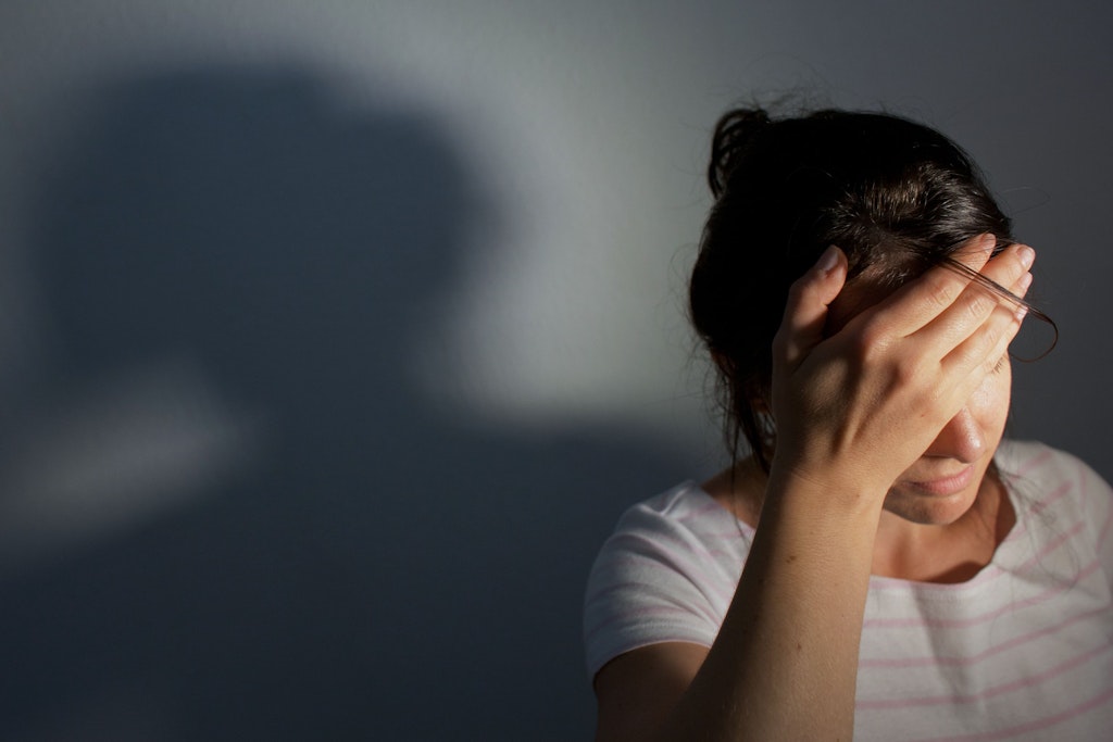 Eine junge Frau fasst sich an den Kopf. Frauen sind drei Mal so häufig von Migräne betroffen wie Männer.