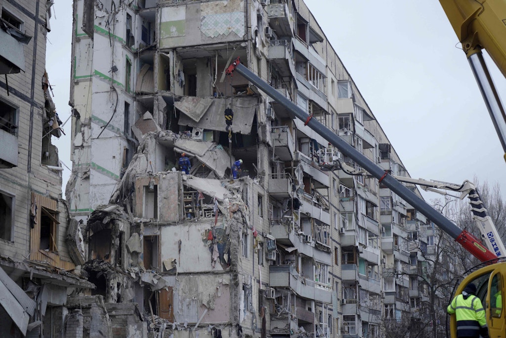 In schwindelnder Höhe sind Rettungskräfte im teilweise eingestürzten Wohnblock der Stadt Dnipro bei der Arbeit.