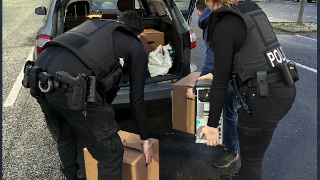In Neukölln packen zwei Polizisten einen Computer und Kisten mit Beweismaterial in den Einsatzwagen, nach dem die Wohnung eines Verdächtigen wegen Kinderpornos durchsucht wurde. 