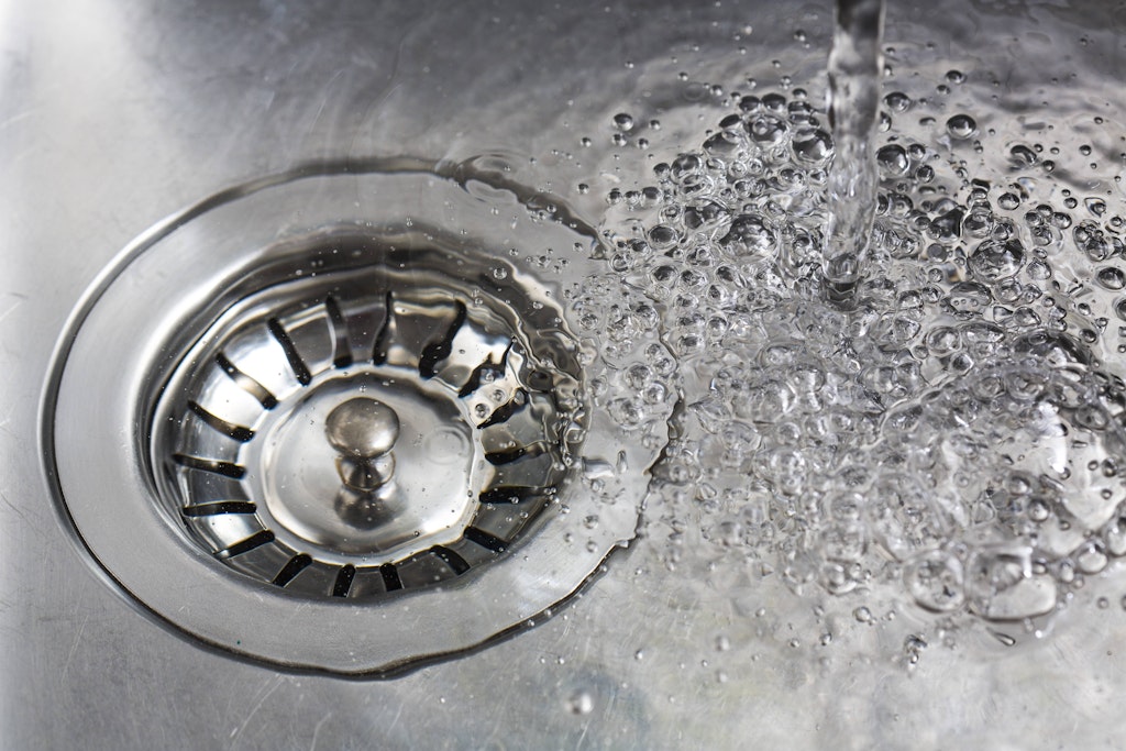 Wasser läuft in einen Abfluss. (Symbolfoto)