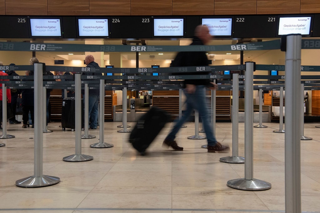 Ein Reisender geht mit einem Koffer zu einem Check-in-Schalter. Die Gewerkschaft Verdi hat für den heutigen Mittwoch einen ganztägigen Warnstreik am Hauptstadtflughafen BER angekündigt. 