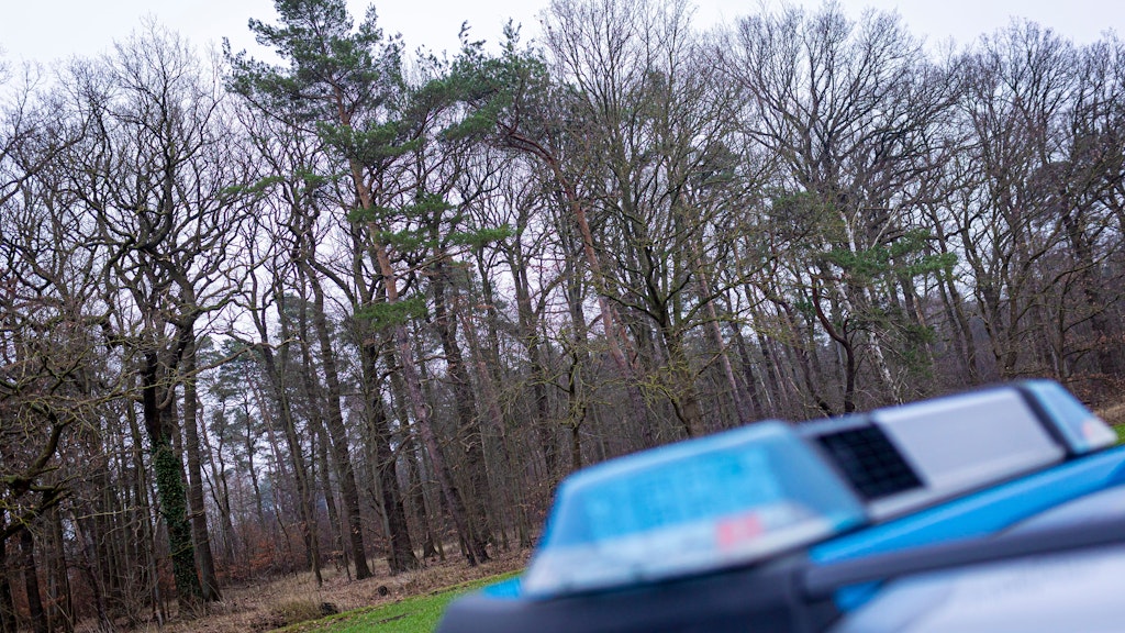 Ein Polizeiauto steht an dem Waldstück in Wunstorf in der Region Hannover, in dem ein womöglich toter 14-Jähriger vermutet wird.