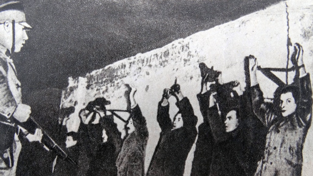 SA-Leute haben in einem Folterkeller verhaftete Kommunisten und Sozialdemokraten an die Wand gestellt.