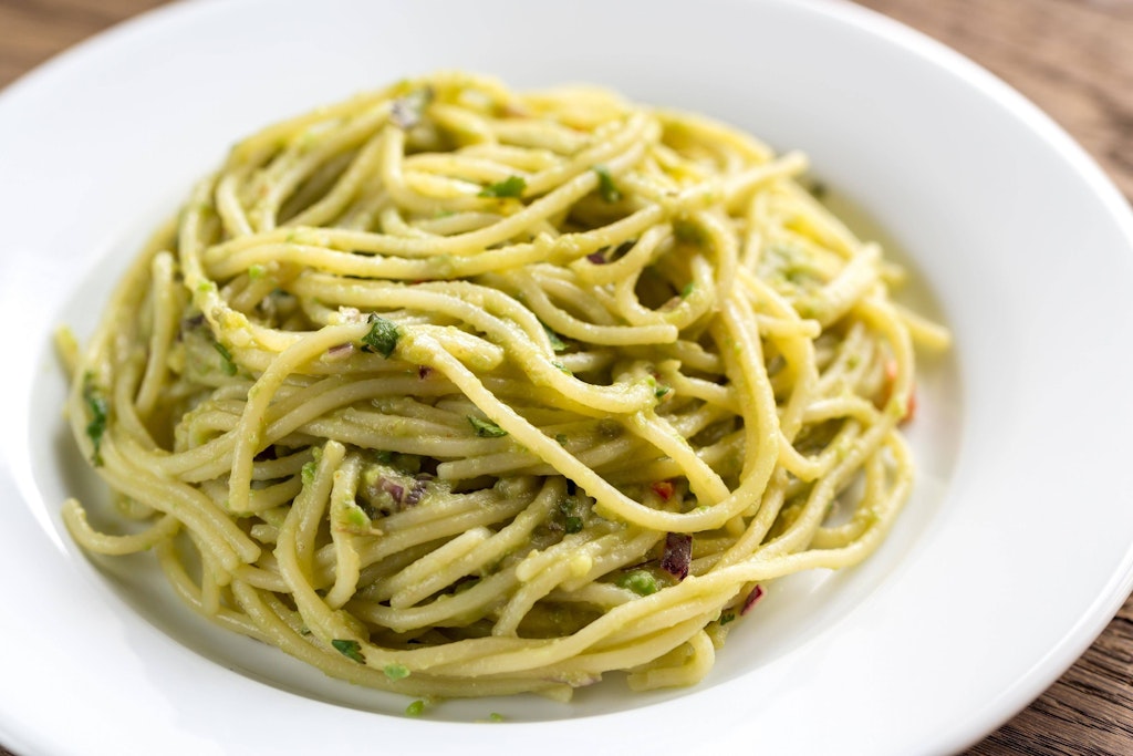 Leckere Spaghetti mit Avocado-Pesto. Je mehr Basilikum Sie nehmen, umso farbenfroher wird das Gericht.