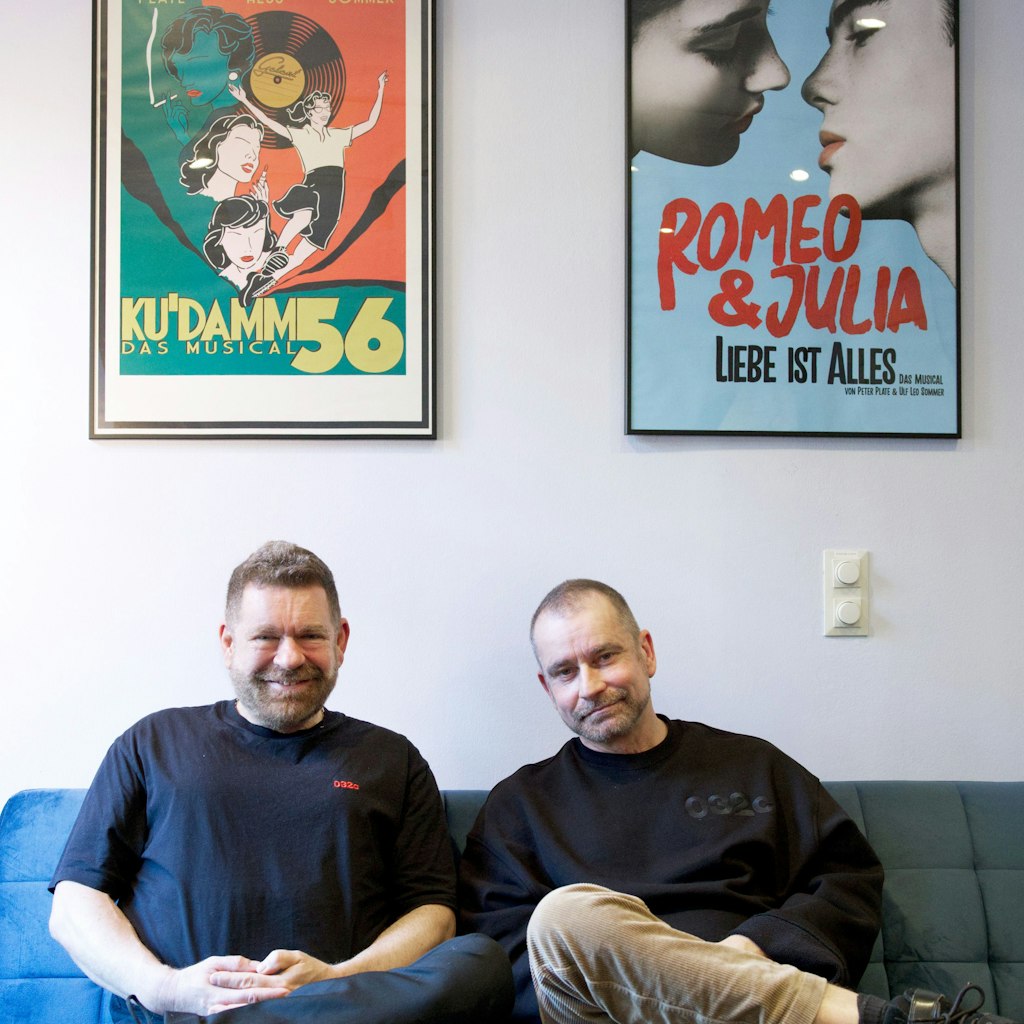 Peter Plate und Ulf Sommer in ihrem Büro im Theater: Über ihnen hängen die Plakate ihrer Musical „Ku’damm 56“ und „Romeo & Julia“.
