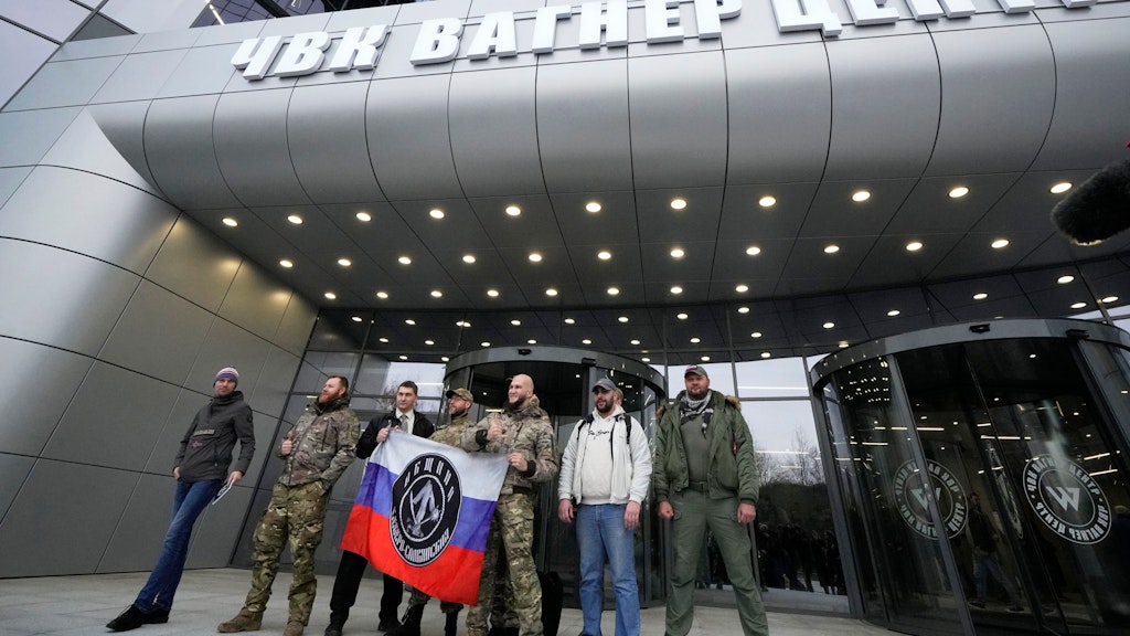 Männer posieren vor dem Firmensitz des Kriegsunternehmens Wagner in St. Petersburg