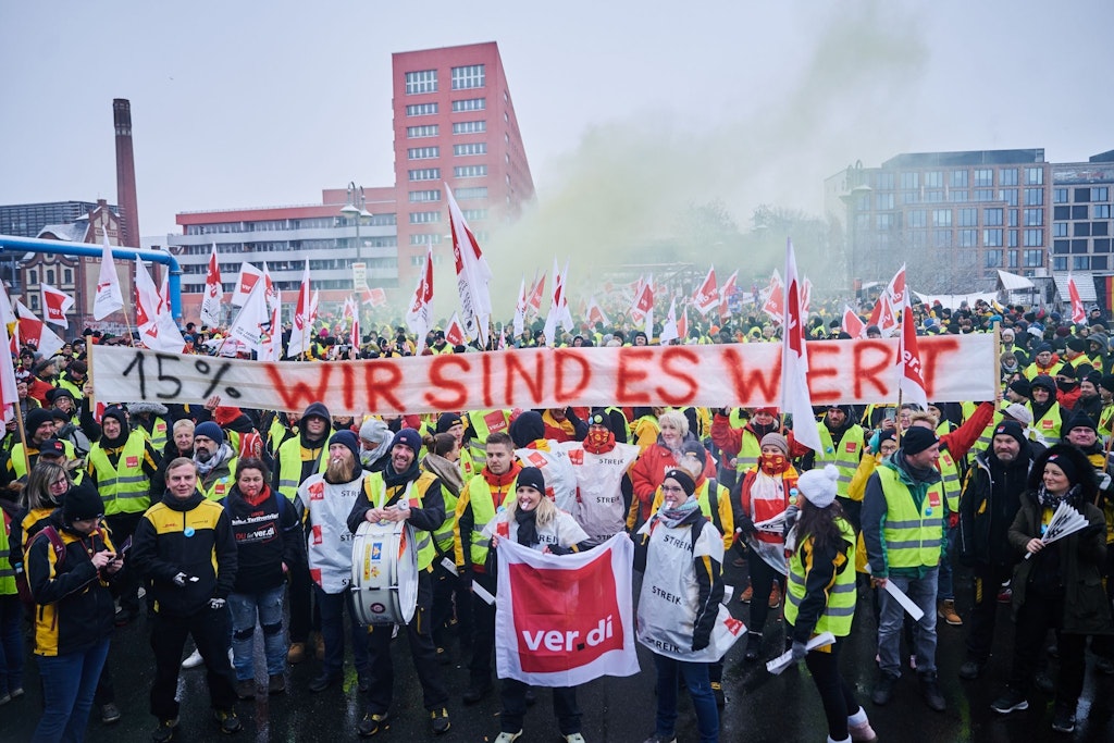 „15 % Wir sind es wert“ steht auf dem Transparent, das streikende Mitarbeiter der Post in Berlin hochhalten.