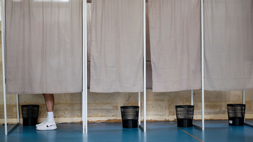 Ein Wähler gibt seine Stimme in einer Wahlkabine in einem Wahllokal ab