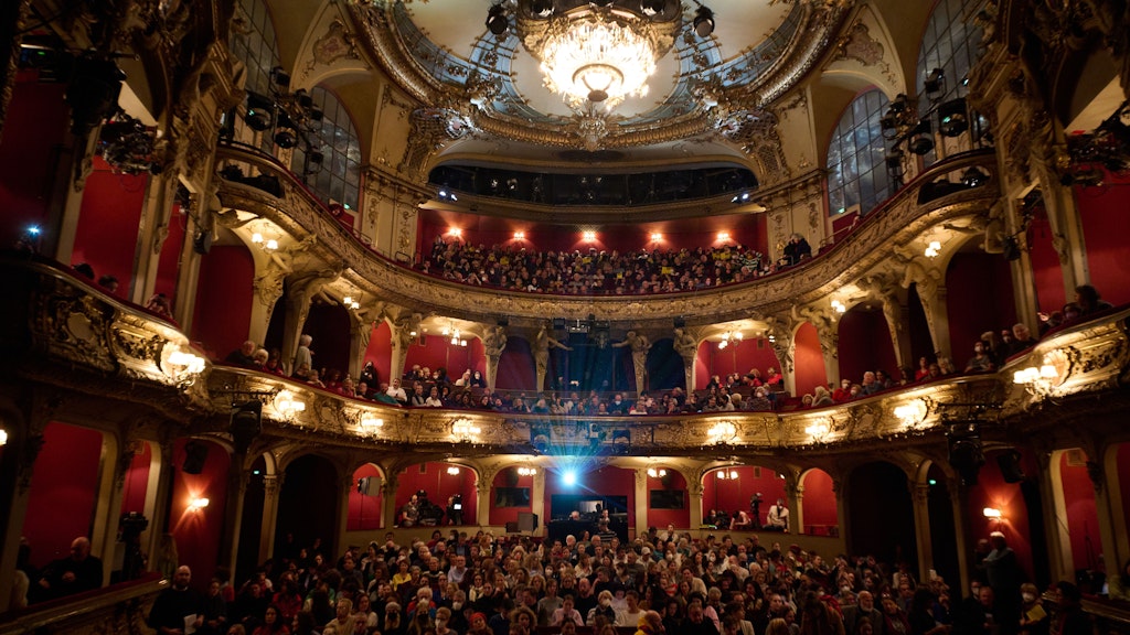  Menschen sitzen im Berliner Ensemble bei der Solidaritätsveranstaltung "Frau Leben Freiheit". 