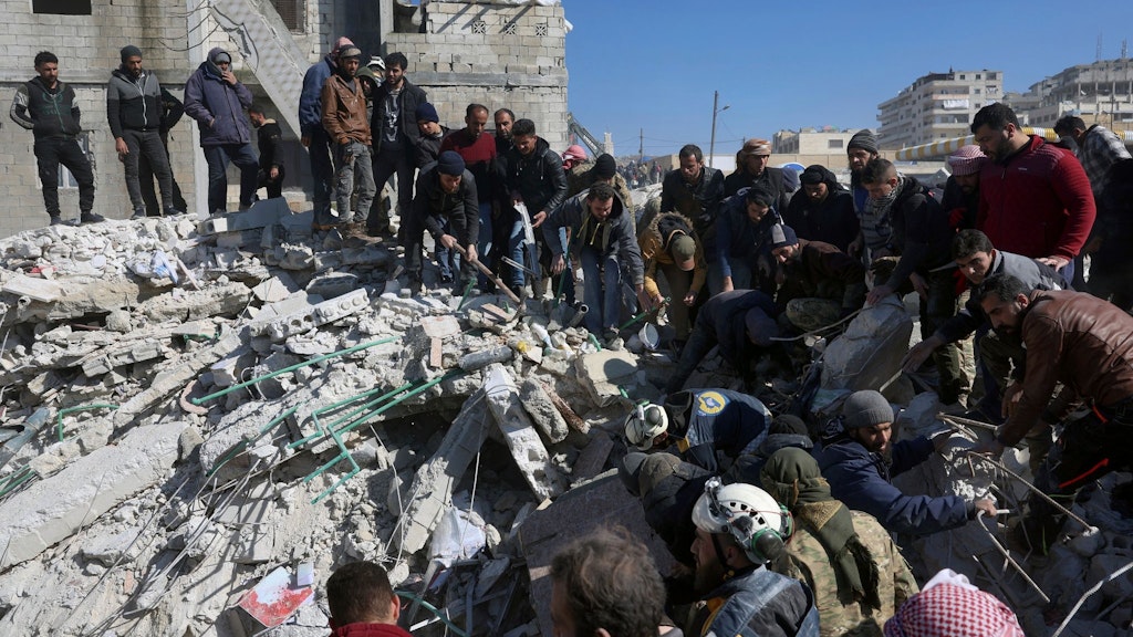 Rettungskräfte und Anwohner durchsuchen in Harem in der syrischen Region Idlib die Trümmer eingestürzter Gebäude.