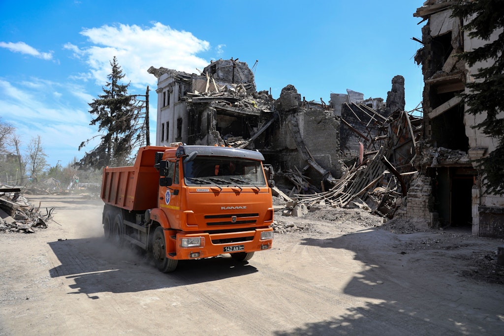 Ein Lkw fährt nach der Eroberung Mariupols durch russische Truppen am zerbombten Theater vorbei, in dem Hunderte bei einem russischen Luftangriff starben.