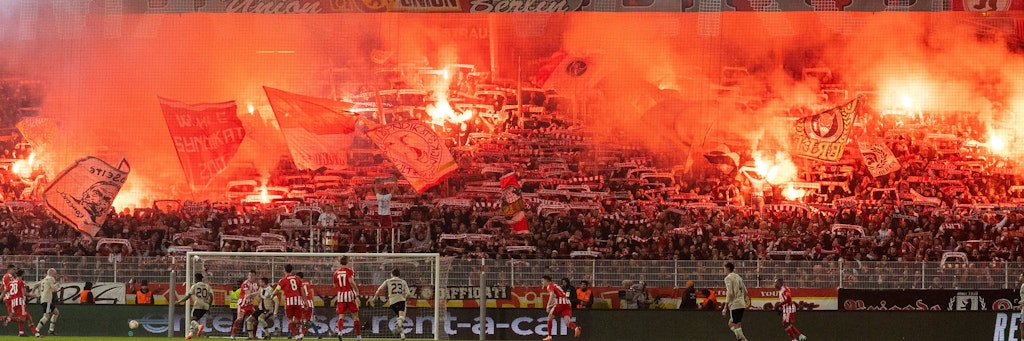 Der Waldseitenblock im Stadion An der Alten Försterei ist taghell erleuchtet durch zahlreiche Pyrofackeln beim Spiel des 1. FC Union gegen Ajax Amsterdam.