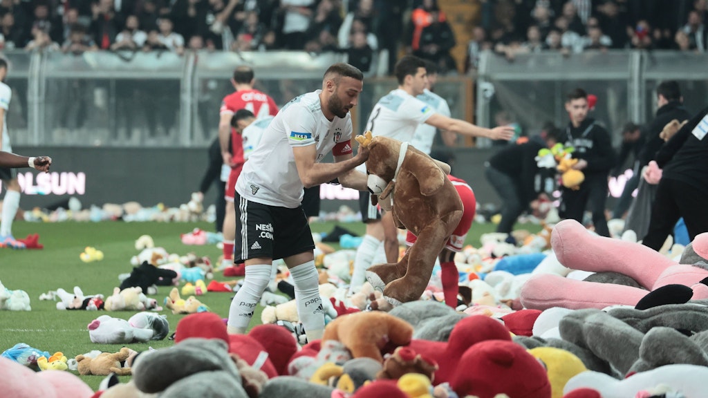 Spieler von Besiktas und Antalyaspor räumen die Spielzeuge vom Feld.