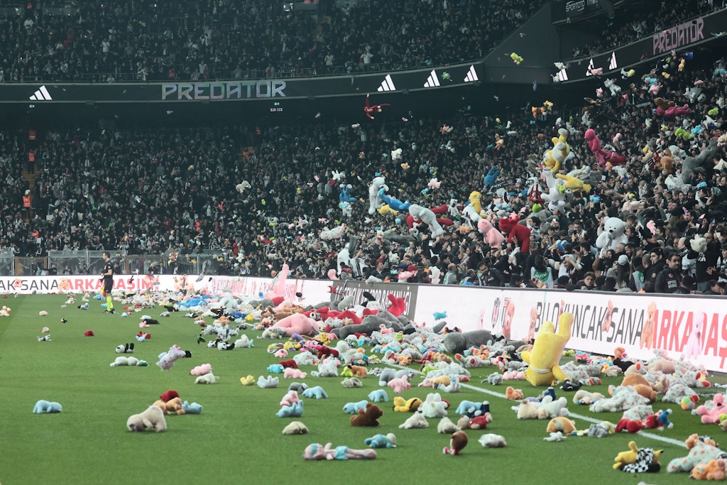 Fans von Besiktas Istanbul werfen Kinderspielzeug auf den Platz.