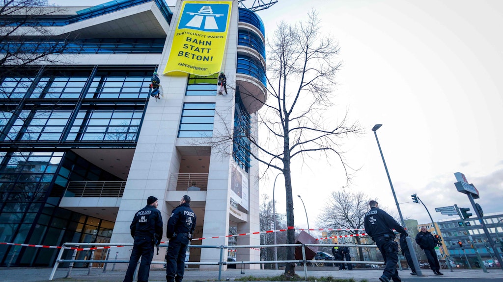 Polizisten haben das SPD-Gebäude abgeriegelt, während die Klimaschützer sich an der Fassade abseilen und das Protestplakat entrollen.