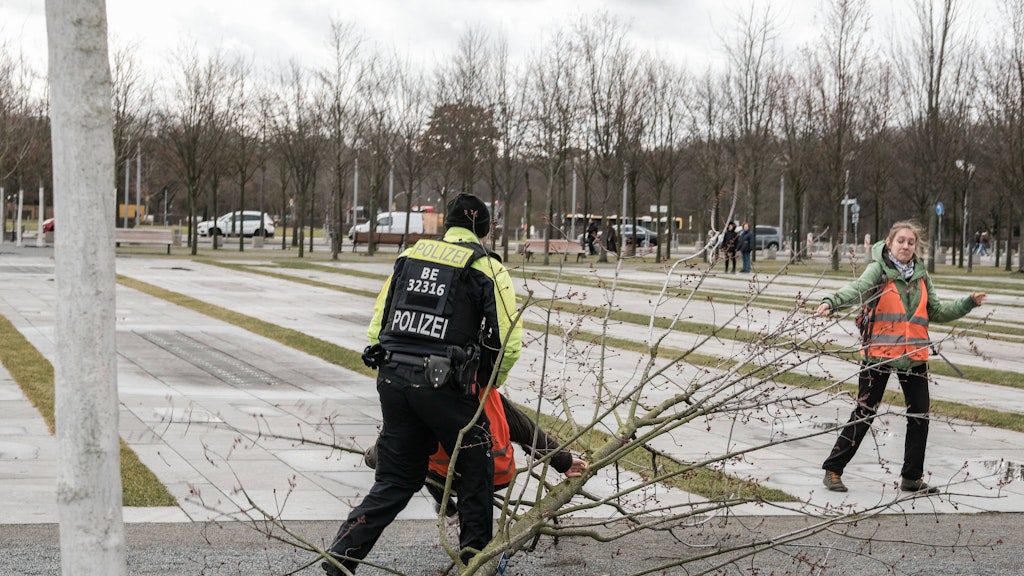 Groteske Aktion: Ein Polizist nimmt einen jungen Baum, den Klima-Aktivisten vor dem Kanzleramt gefällt hatten.