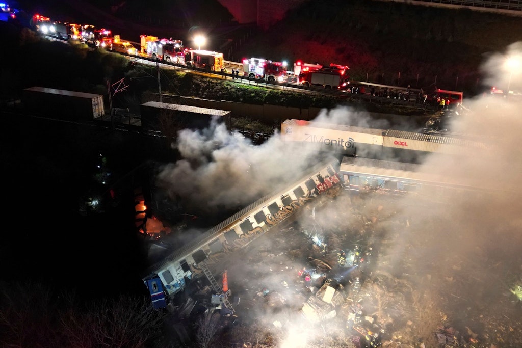 Rauch steigt auf, während Feuerwehrleute und Rettungskräfte nach dem Zusammenstoß zweier Züge in Griechenland nahe Larisa im Einsatz sind.